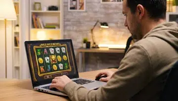 a guy playing an online slot machine on his laptop