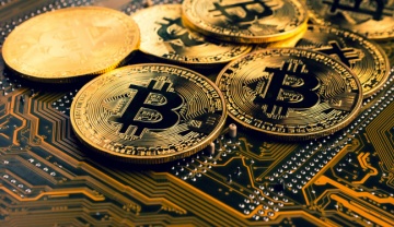 bright gold bitcoin coins lying on a circuit board