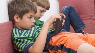 boys playing Roblox on tablets