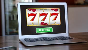 laptop screen showing a 777 spin on a slot machine