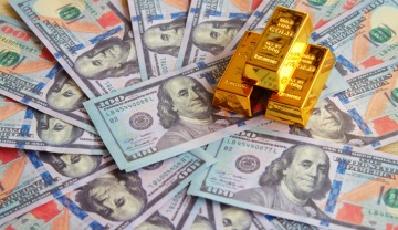 Gold bars on top of dollar bills