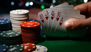 poker hand showing a royal flush with stacks of chips