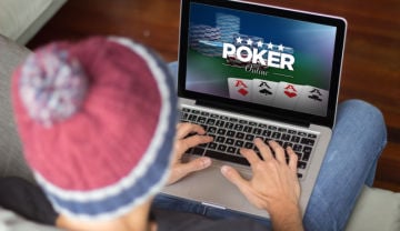 view from behind a guy playing playing poker online on a laptop on his lap