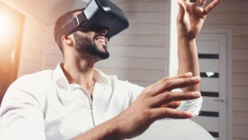 man wearing VR headset reaching for things he "sees" in the air