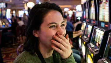 Une femme debout devant des machines à sous 