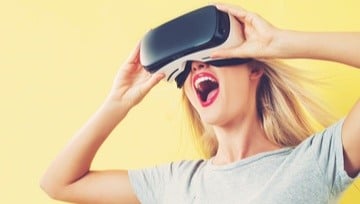 young woman wearing a VR headset and very excited