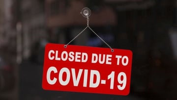 sign on a glass door: Closed due to Covid-19