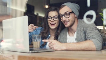 couple having fun playing on their laptop together
