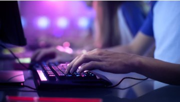 a gamer's fingers hovering over his computer keyboard