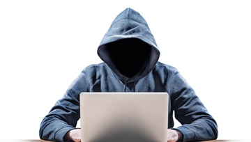 hacker guy sitting at a laptop with a hoodie and no face