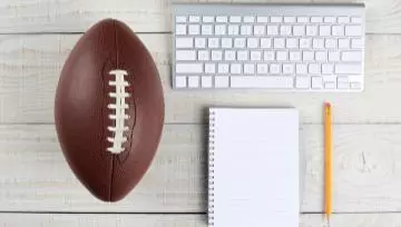 football, notebook and computer sitting on a table