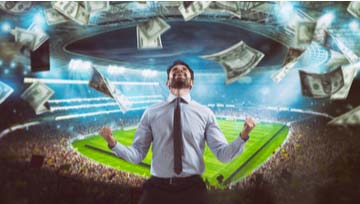 man celebrating a win betting on a football game with cash bills floating all around him