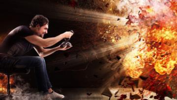 a man sitting playing a game on his TV screen blowing it up