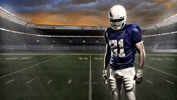 photo of a football player standing on the field in a stadium