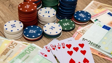 playing cards on the table with EU chips and cash bills