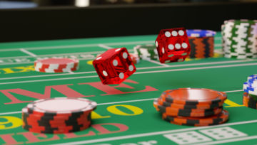 Close up of a craps table with chips and flying dice