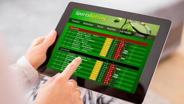 sports betting screen on a tablet with a guy about to click