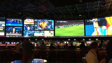 sportsbetting arena with large screens all around the room