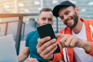 Two men check their sports betting app for wins