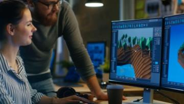 Two gaming designers looking at the computer together working on a project.