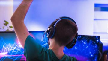 young man cheering himself on playing a video game  
